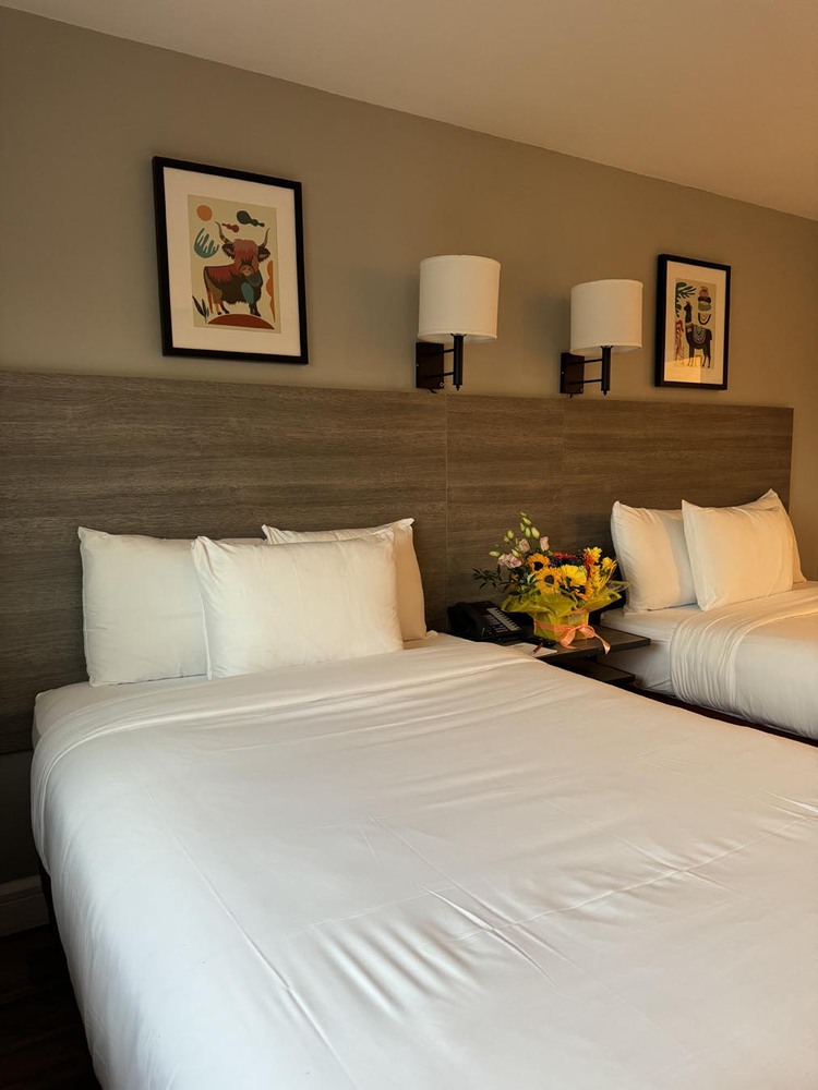 Flowers on nightstand in hotel room with two beds