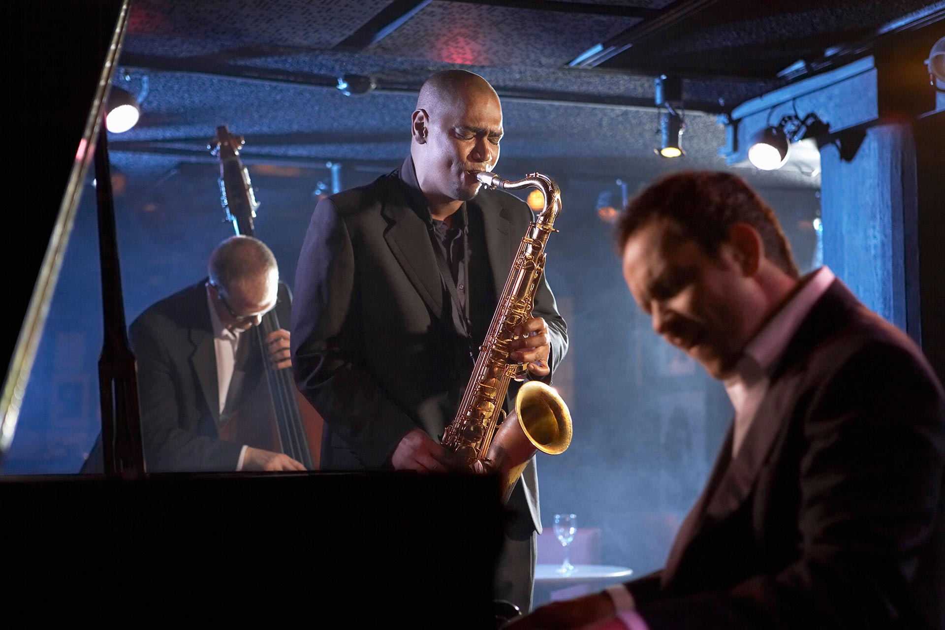A jazz band of three musicians performing in a venue