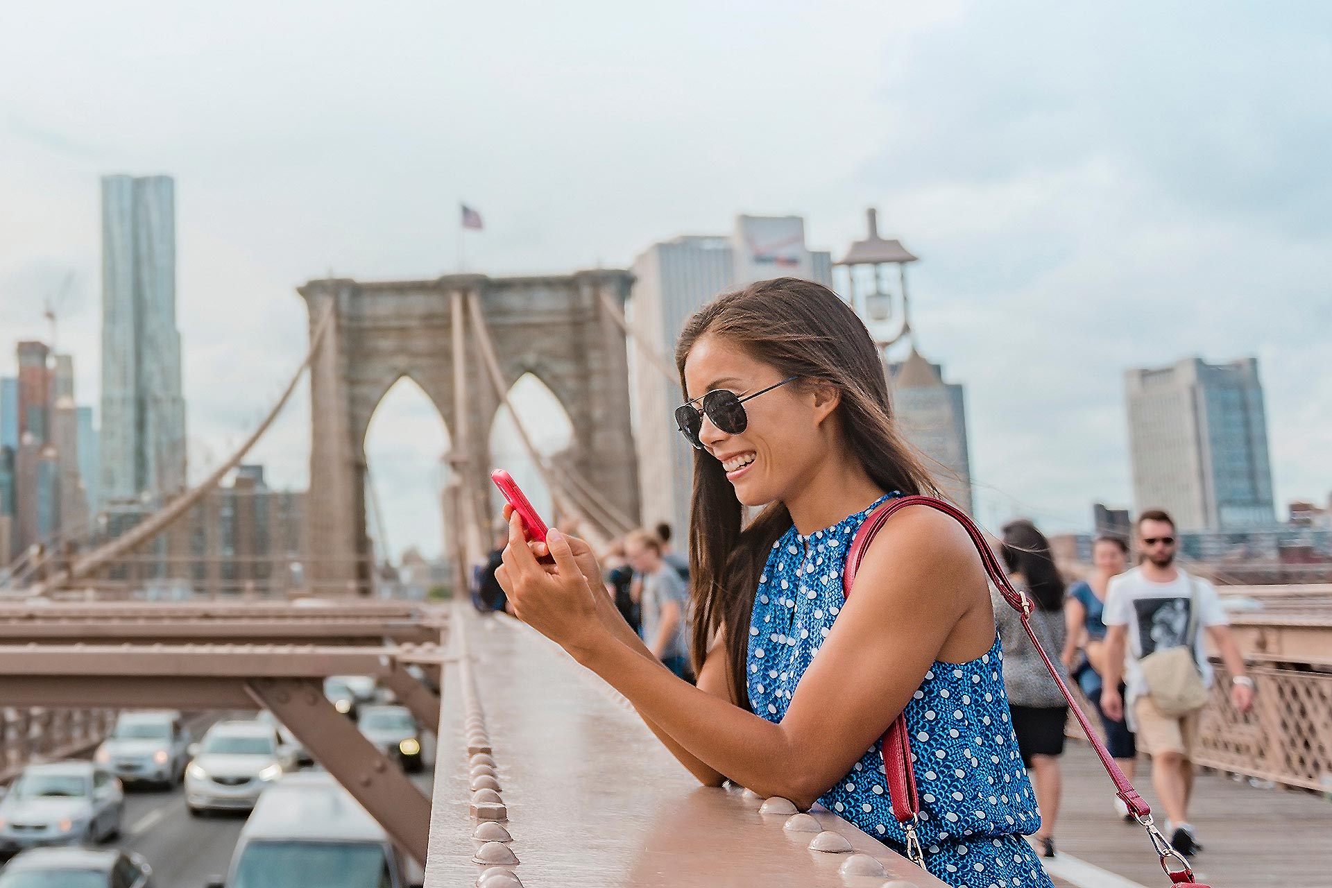 A woman on her phone at the Brooklyn Bridge